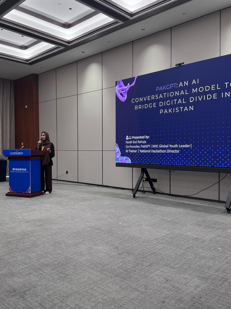 Farah Gul Rahuja presenting PakGPT at a conference podium