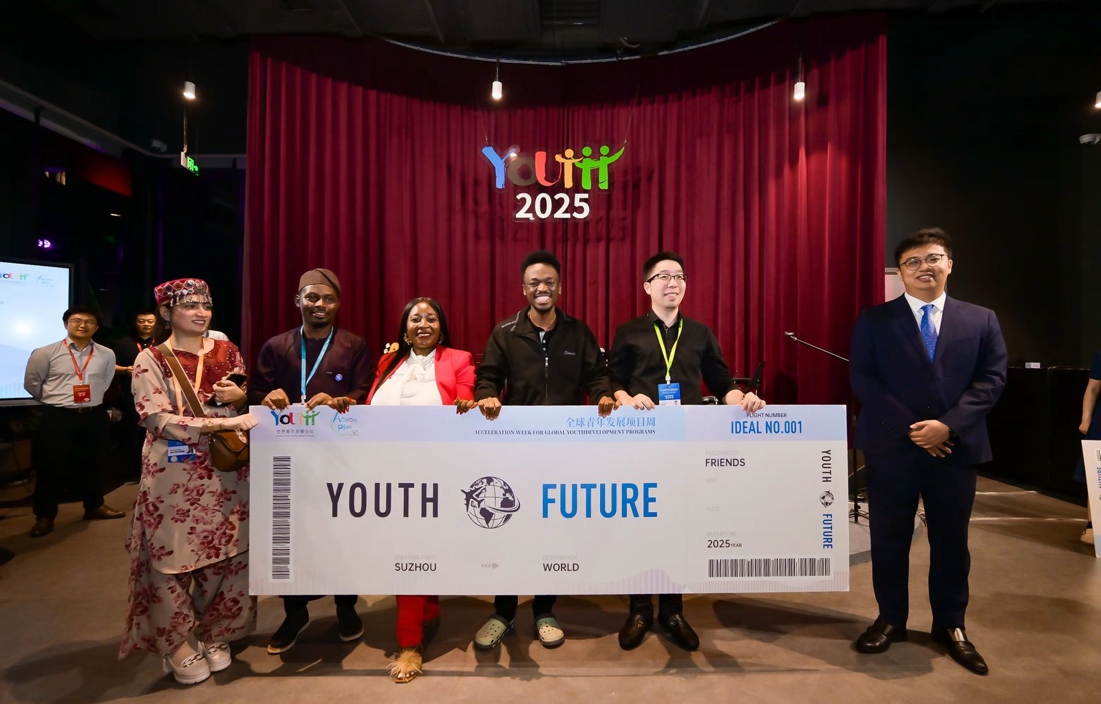 Delegates holding a giant Youth Future boarding pass banner at Youth 2025